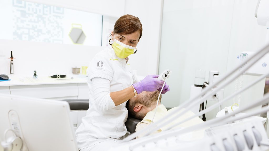 Dentista en acción realizando una obturación dental en la Clínica Dental Manresa