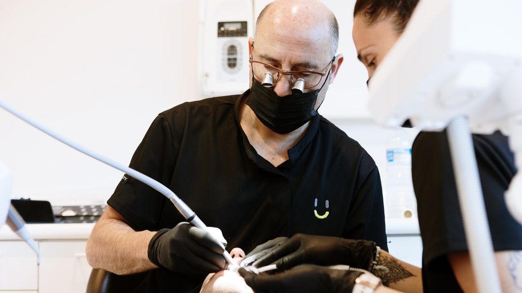 doctor de estética dental trabajando en la colocación meticulosa de carillas en la Clínica Dental Manresa.