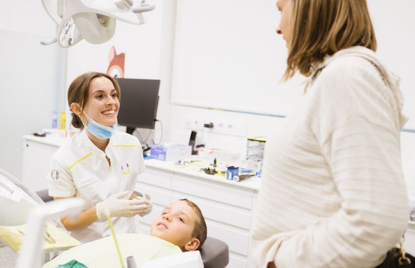 Un nen petit feliç al dentista amb la seva mare per primera vegada